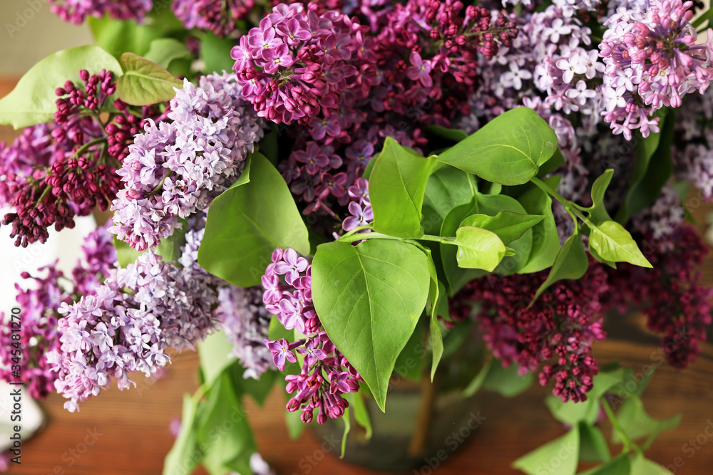 Beautiful lilac flowers on table, closeup