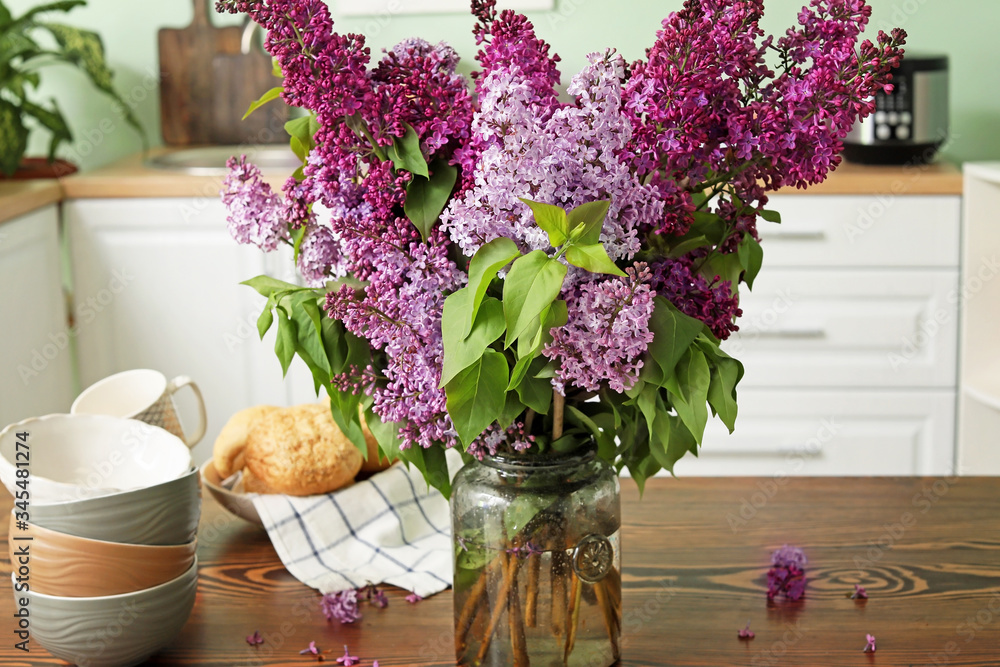 Beautiful lilac flowers on table in kitchen