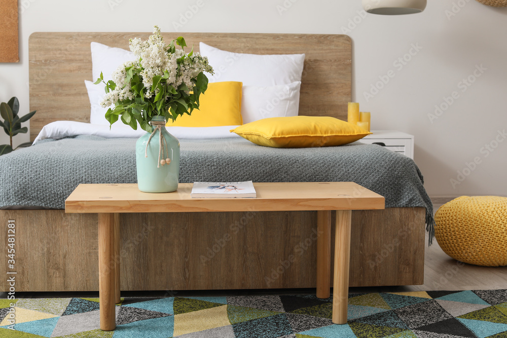 Beautiful lilac flowers on table in bedroom