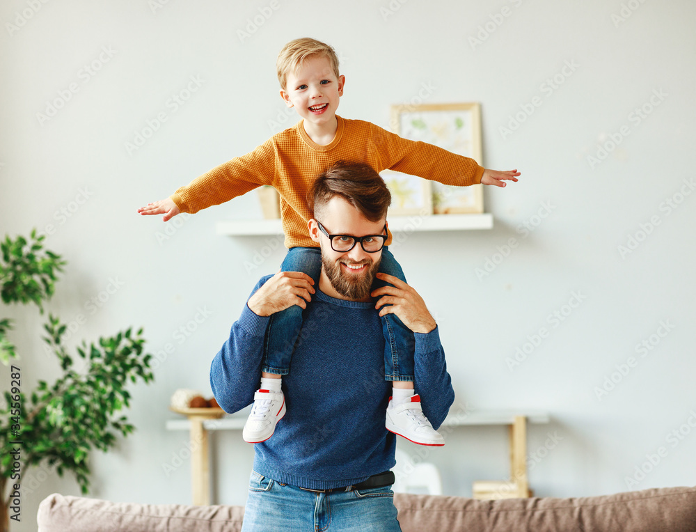 Happy father and son having fun at home.