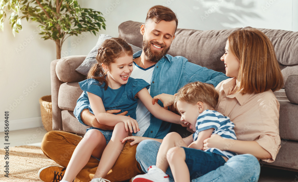 Cheerful parents with kids having fun at home.