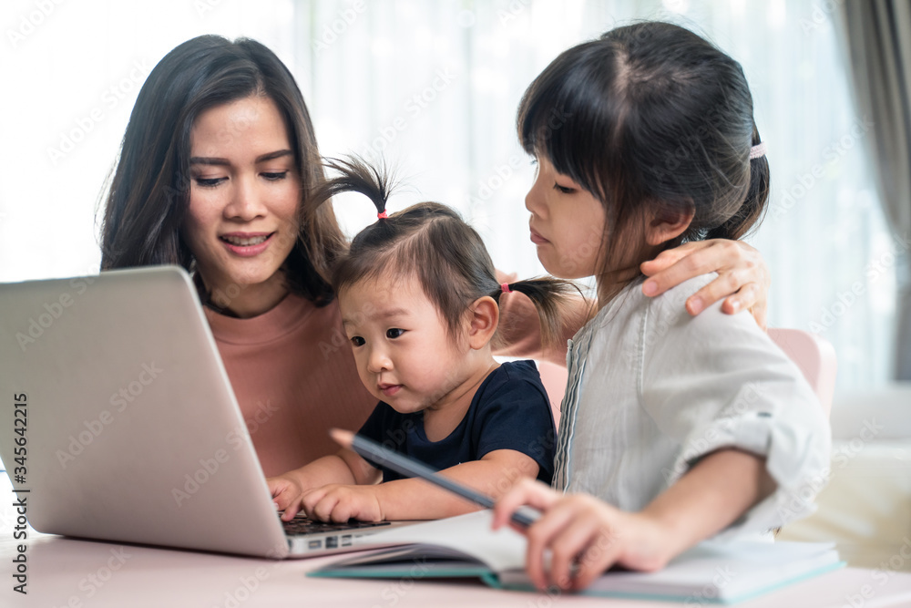 亚洲幼儿在家与母亲在线学习互联网。