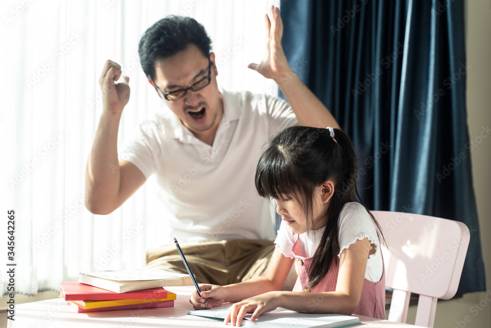 Homeschool Asian young little girl learning, reading and does homework with mean dad strictly  teach