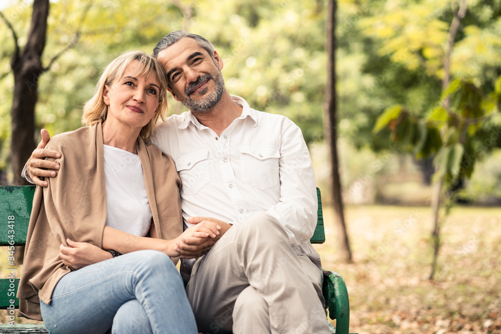 Caucasian senior elder couple sit on bench in park. Mature happy and enjoy with slow life. Old man h