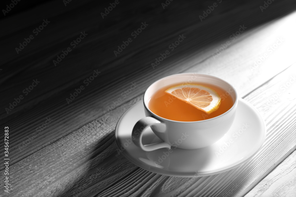 Cup of tea with lemon on white wooden table