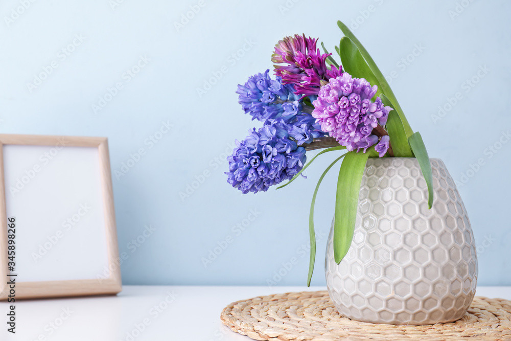 Vase with beautiful hyacinth flowers on table