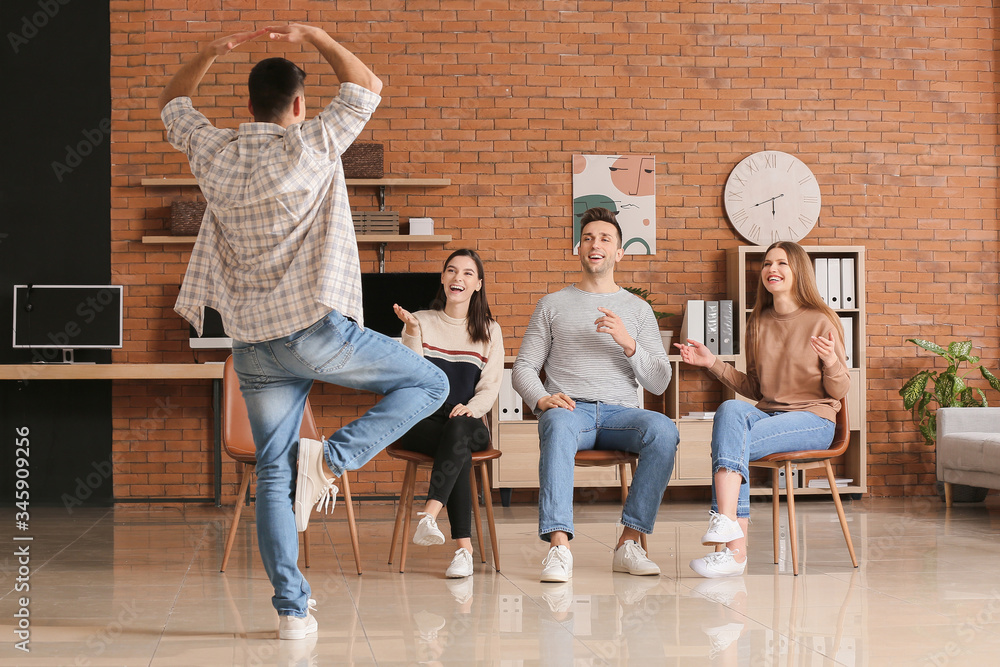 Team of business people playing charades in office