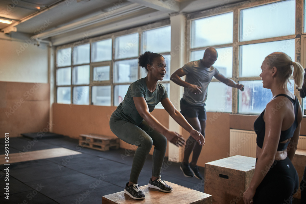 Fit woman doing box jumps during a gym workout