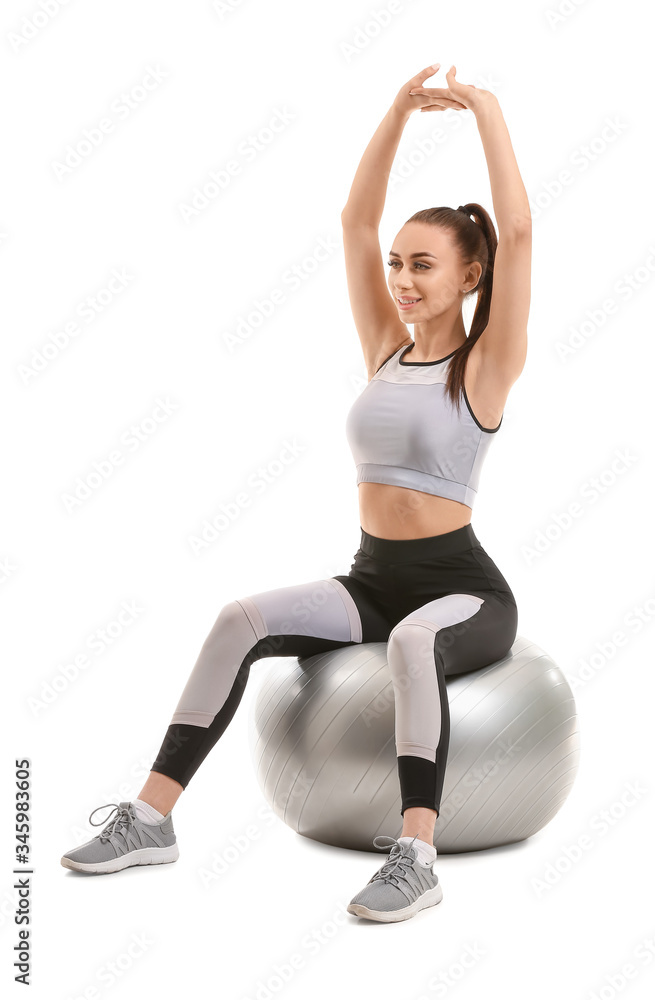 Sporty young woman with fitball on white background