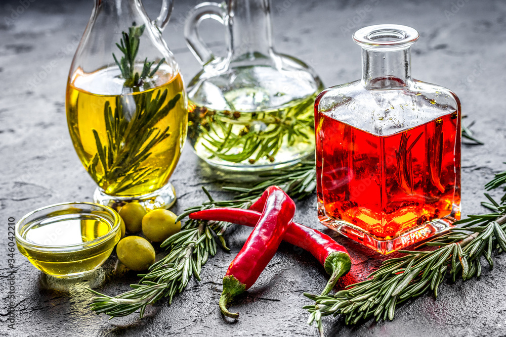 jar with oil with chili on stone table background