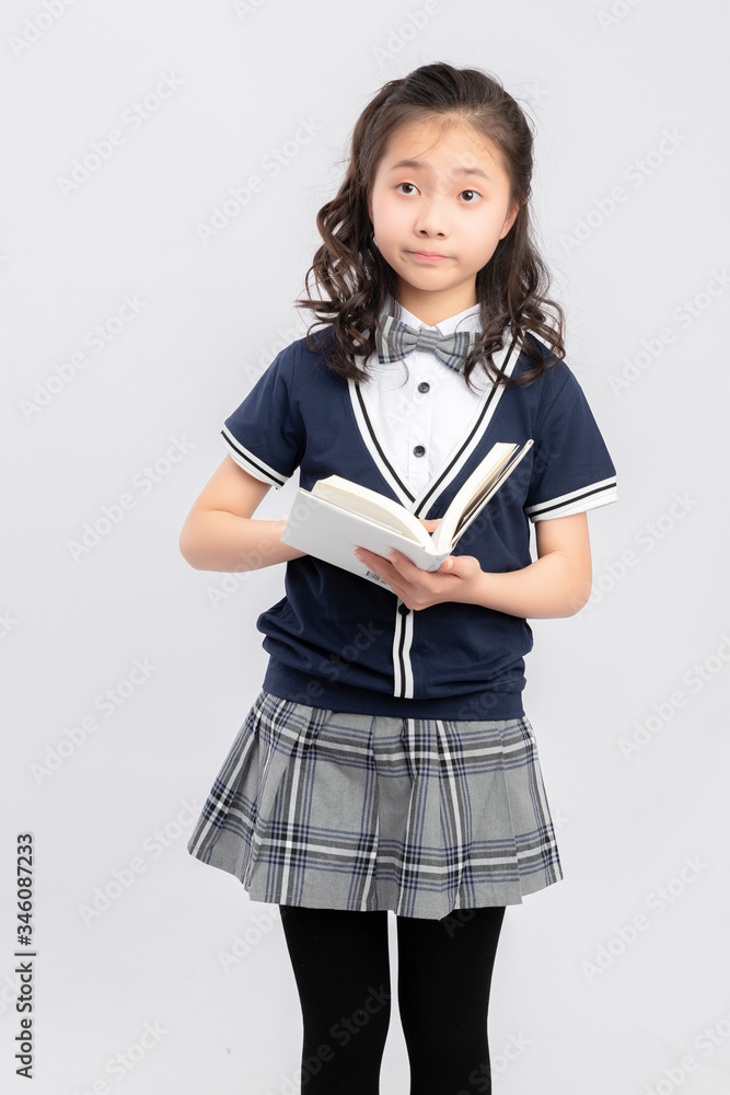 Asian primary  school girls in school uniforms on a gray background