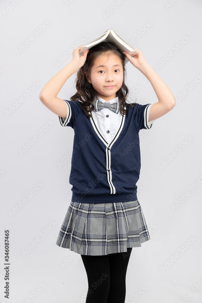 灰色背景下穿着校服的亚洲小学女生