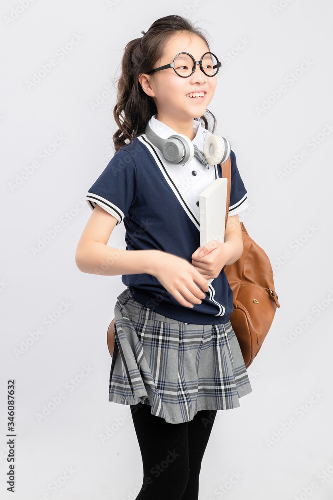 灰色背景下穿着校服的亚洲小学女生