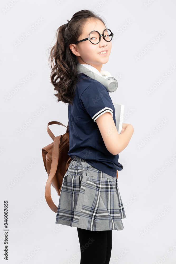 灰色背景下穿着校服的亚洲小学女生