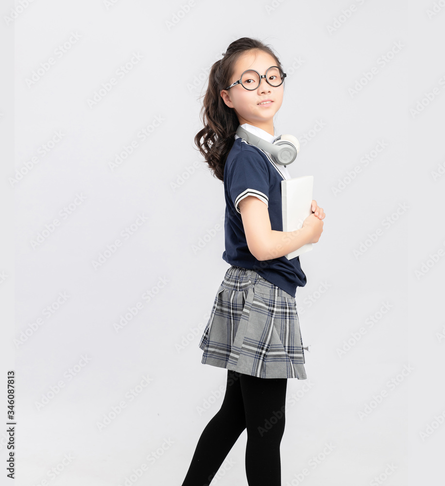 Asian primary  school girls in school uniforms on a gray background