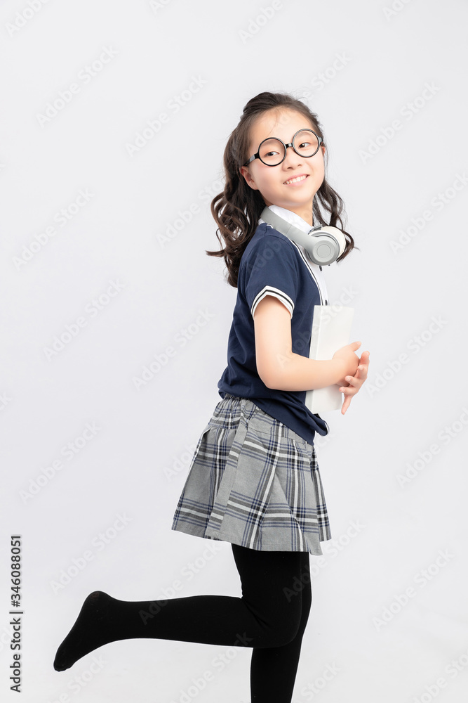 灰色背景下穿着校服的亚洲小学女生