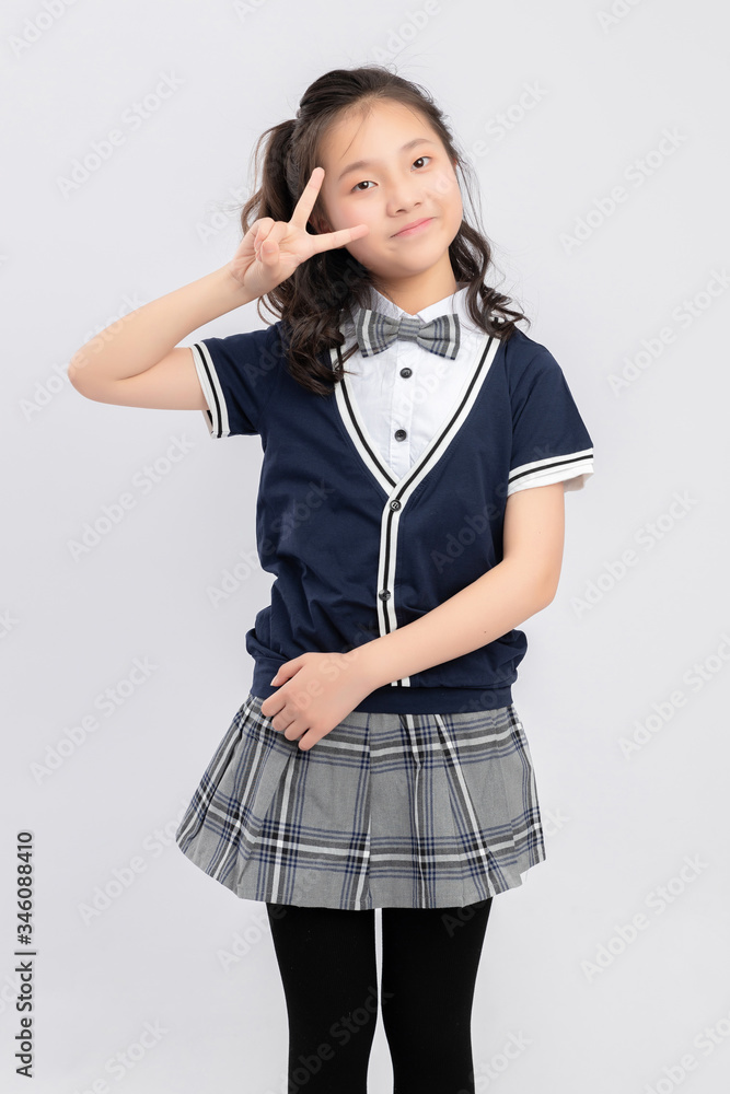 灰色背景下穿着校服的亚洲小学女生