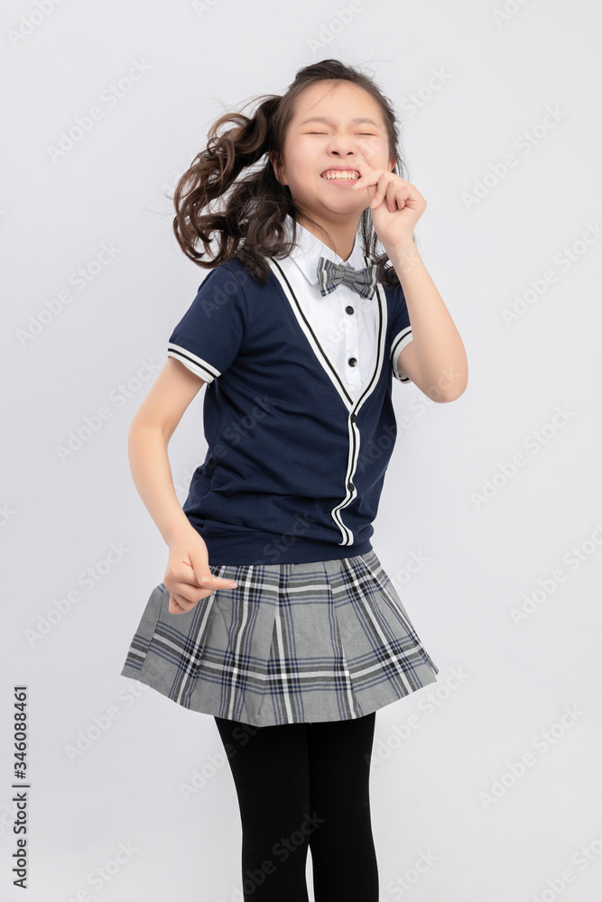 灰色背景下穿着校服的亚洲小学女生