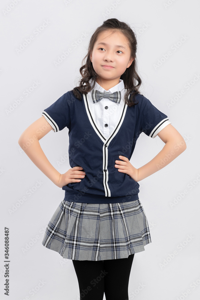 灰色背景下穿着校服的亚洲小学女生