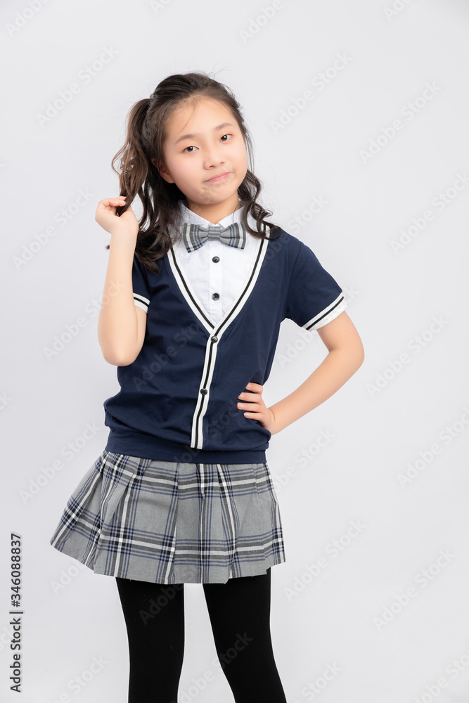 灰色背景下穿着校服的亚洲小学女生