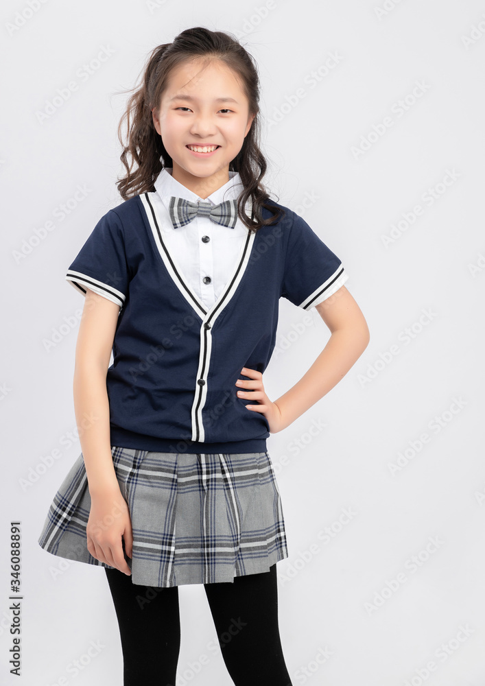 灰色背景下穿着校服的亚洲小学女生