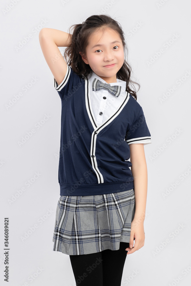 灰色背景下穿着校服的亚洲小学女生