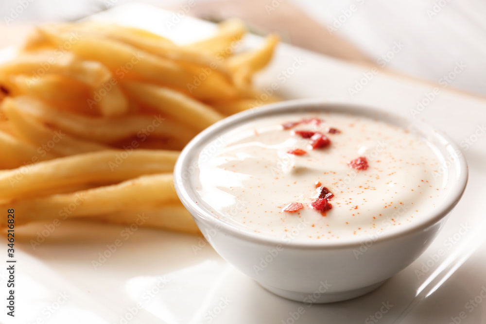 Plate with tasty sour cream and french fries, closeup