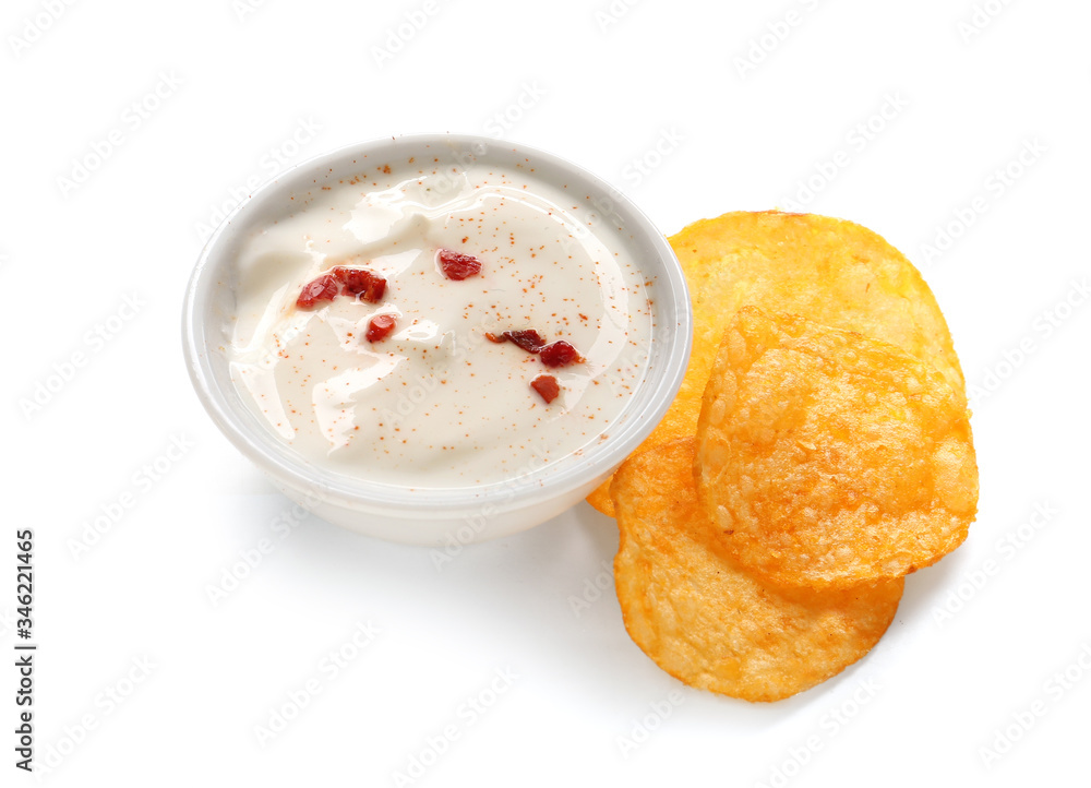 Bowl with tasty sour cream and potato chips on white background