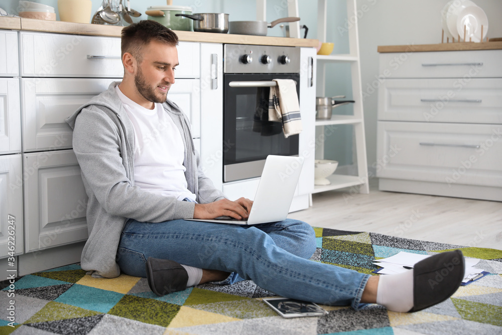 Young man with laptop working at home