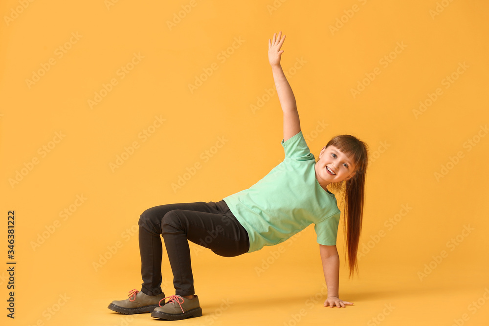 Cute little girl dancing against color background