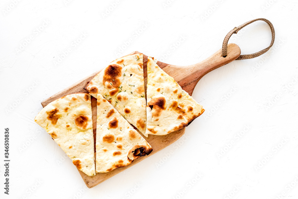 Make focaccia. Traditional italian bread on cutting board on white table top-down copy space