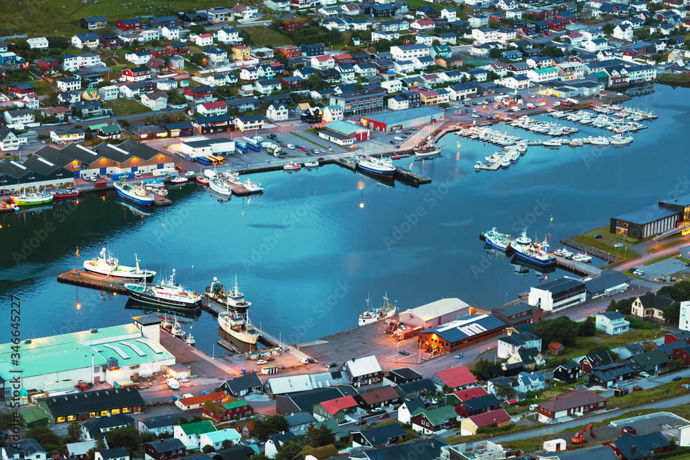 Breathtaking evening cityscape of Klaksvik town with fjord, pier, ships and boats, Bordoy island, Fa