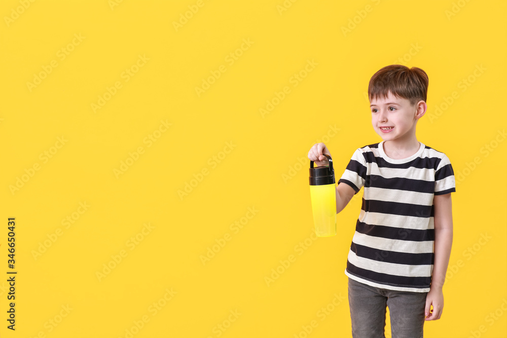 Little boy with flashlight on color background