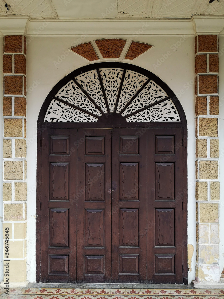 The old wooden doors of the ancient house with beautiful carved patterns.