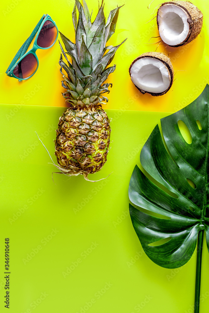 summer mix with sun glasses, pineapple and coconut yellow background top view mockup