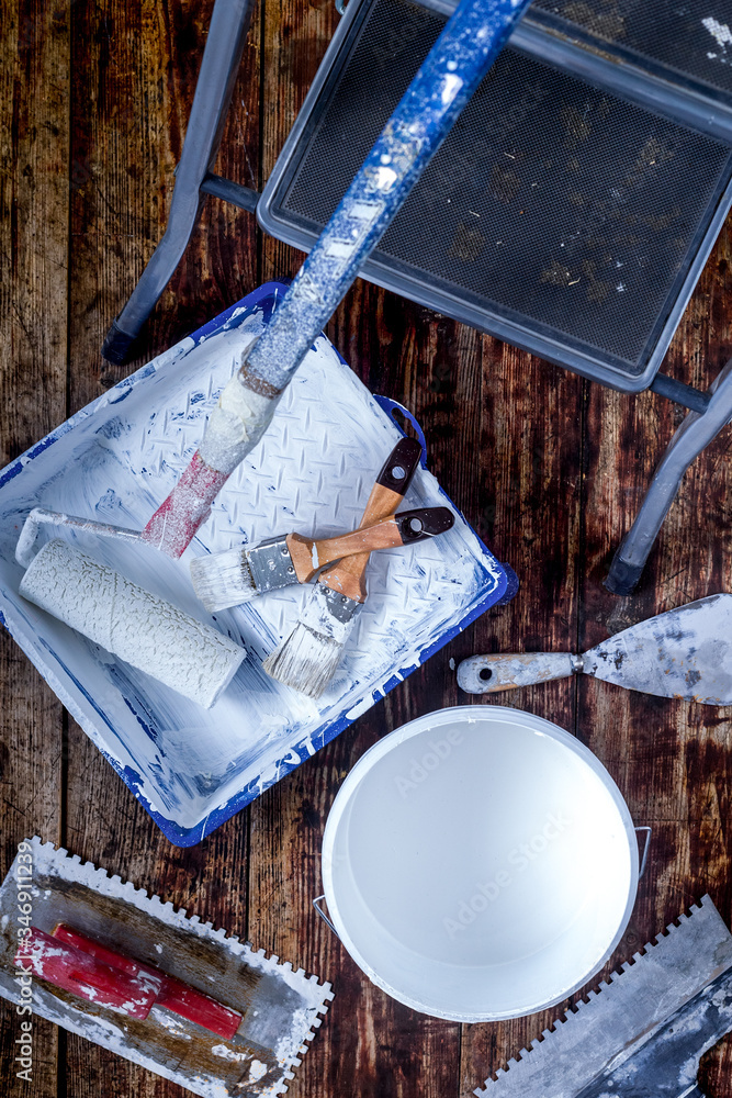 building decoration instruments with paint, roller, palette-knife on wooden background top view