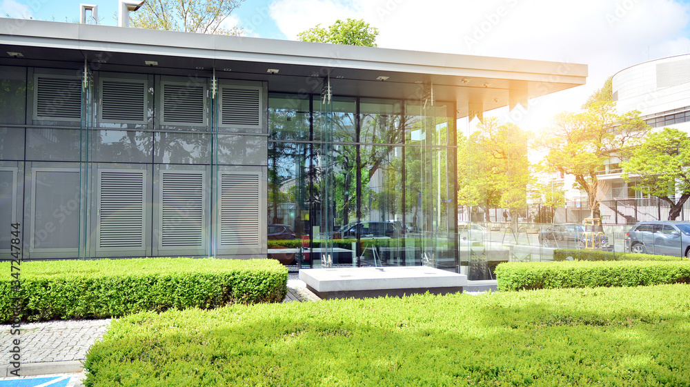 Modern architecture with sun ray. Glass facade on a bright sunny day with sunbeams on the blue sky.