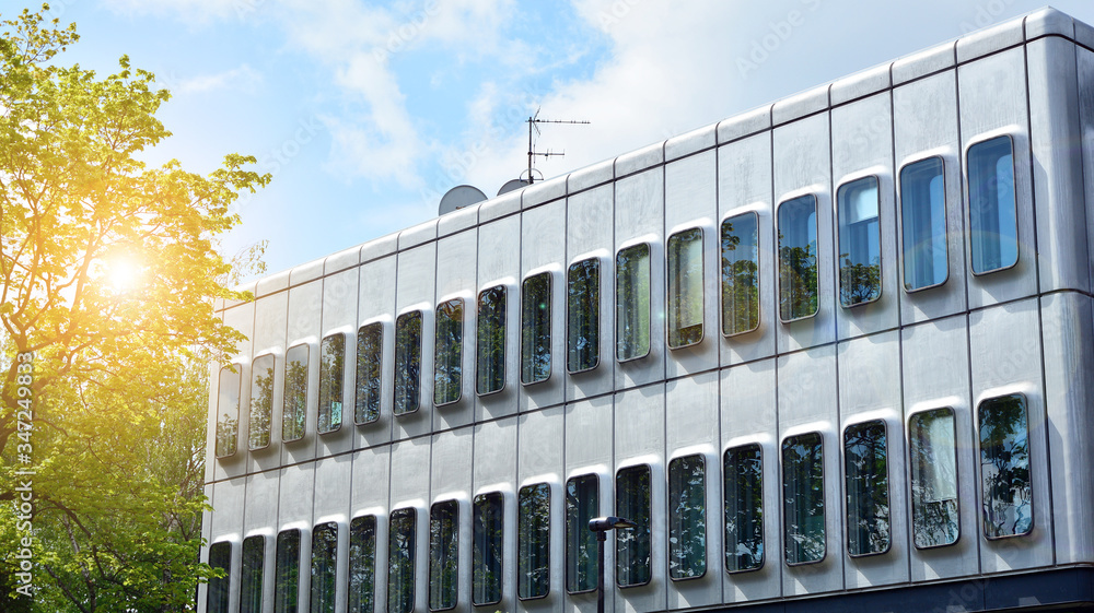 Modern architecture with sun ray. Glass facade on a bright sunny day with sunbeams on the blue sky.