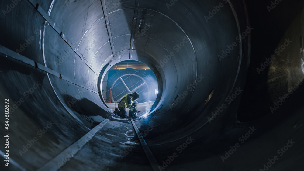 Professional Heavy Industry Worker Wearing Helmet Welding Inside Oil and Gas Pipe. Construction of t