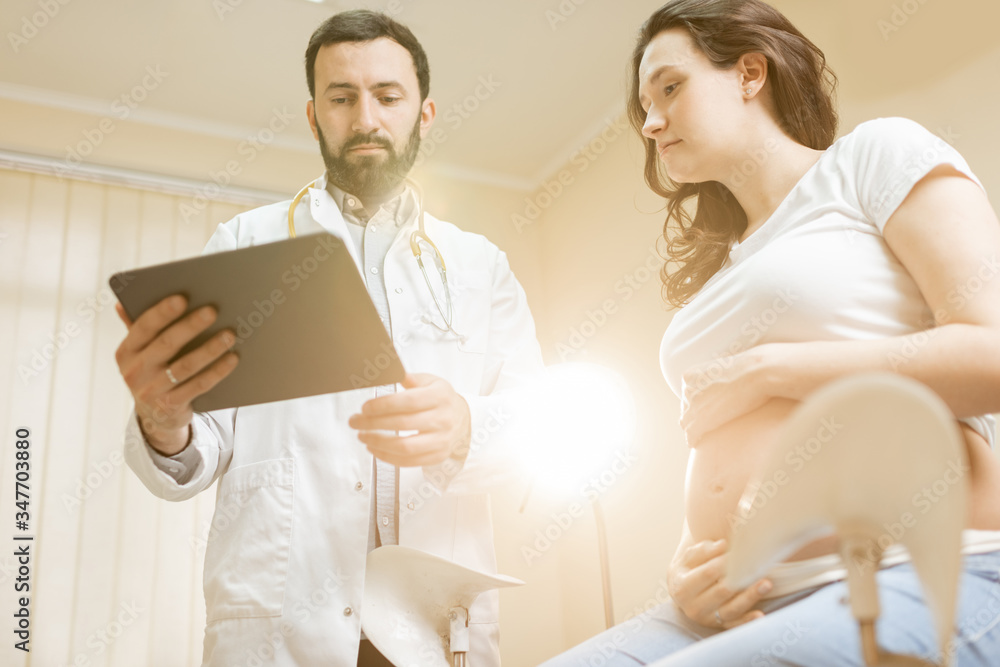 Doctor with pregnant woman during a medical consultation in gynecological office. Concept of medical