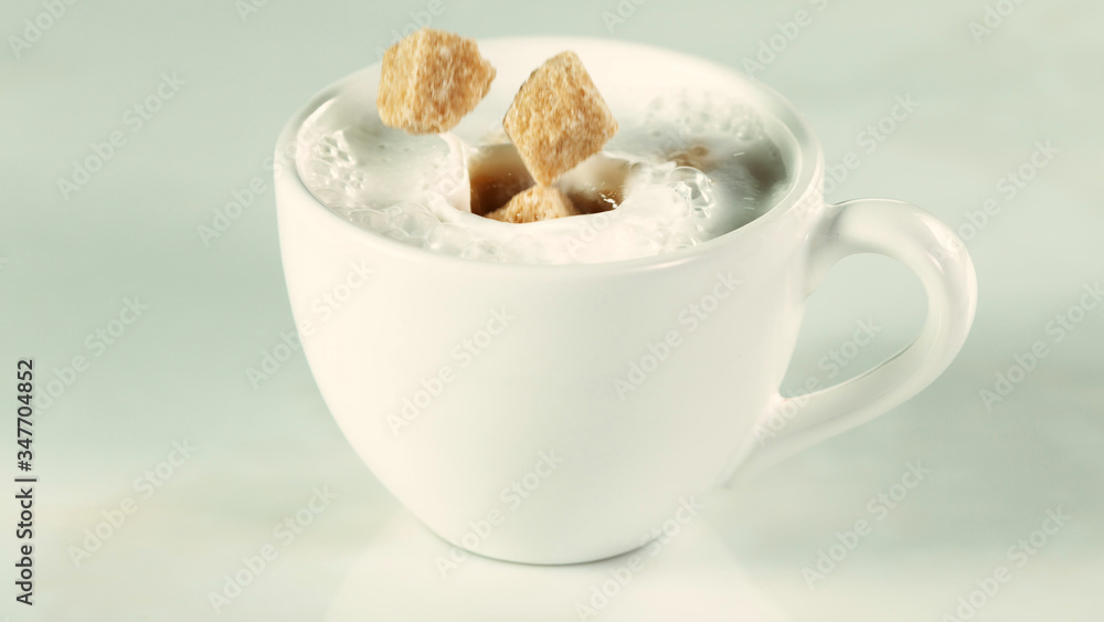 A cup with falling brown sugar canes.