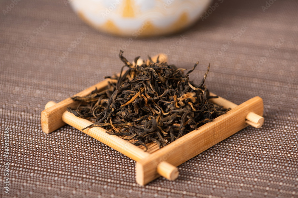 A wooden tray holding black tea leaves.