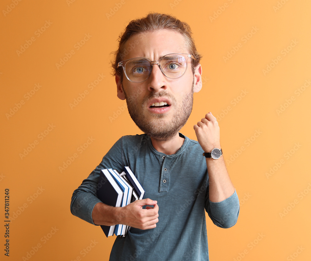 Stressed male student with big head on color background