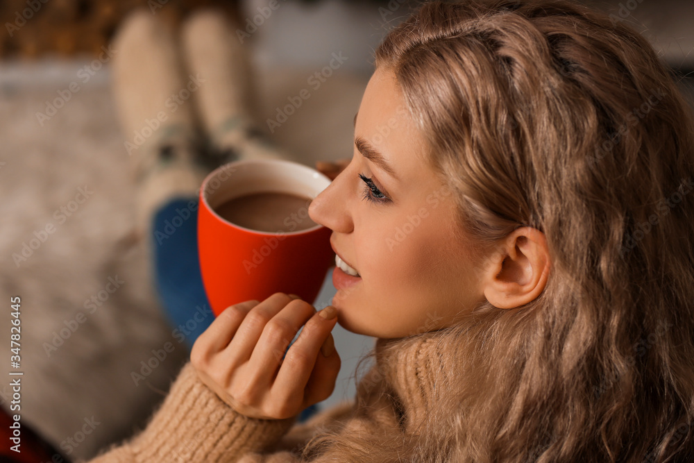 Beautiful young woman drinking hot chocolate at home