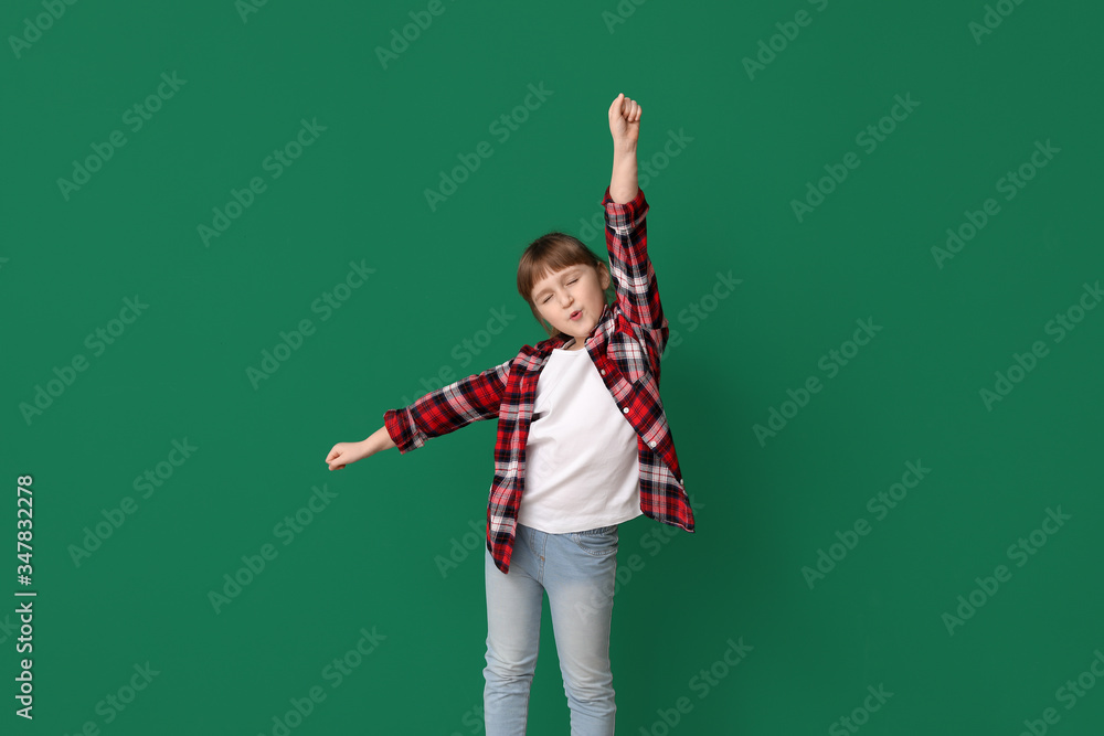 Cute little girl dancing against color background