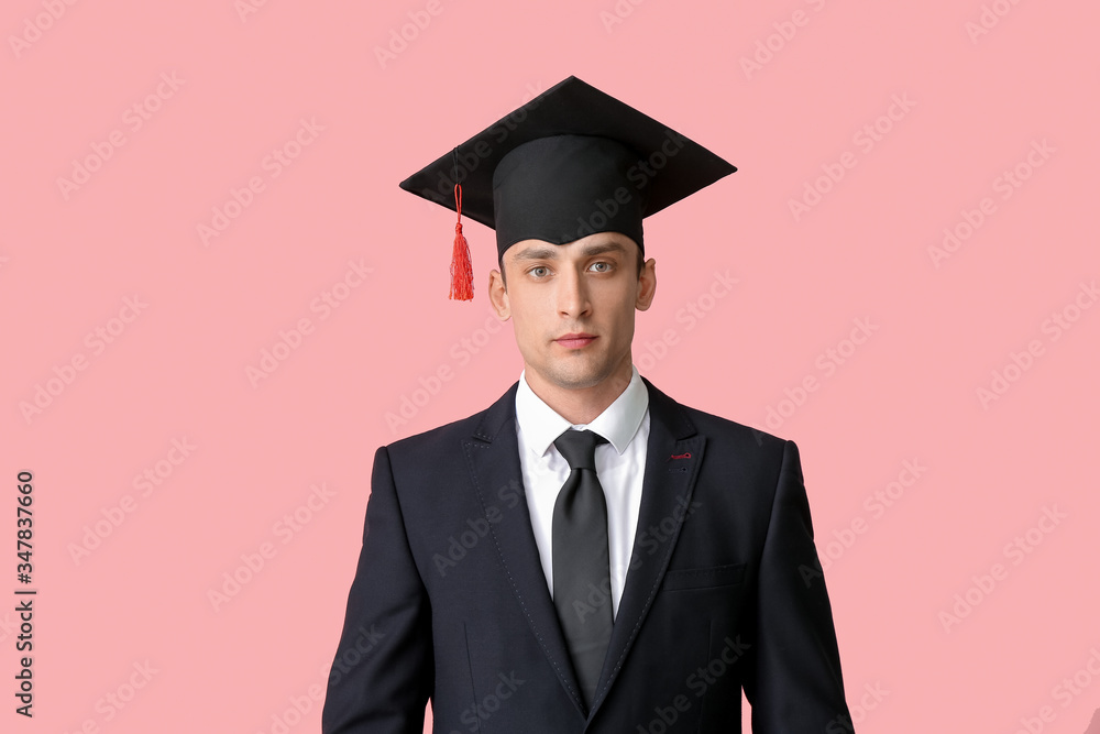 Young man in graduation hat on color background