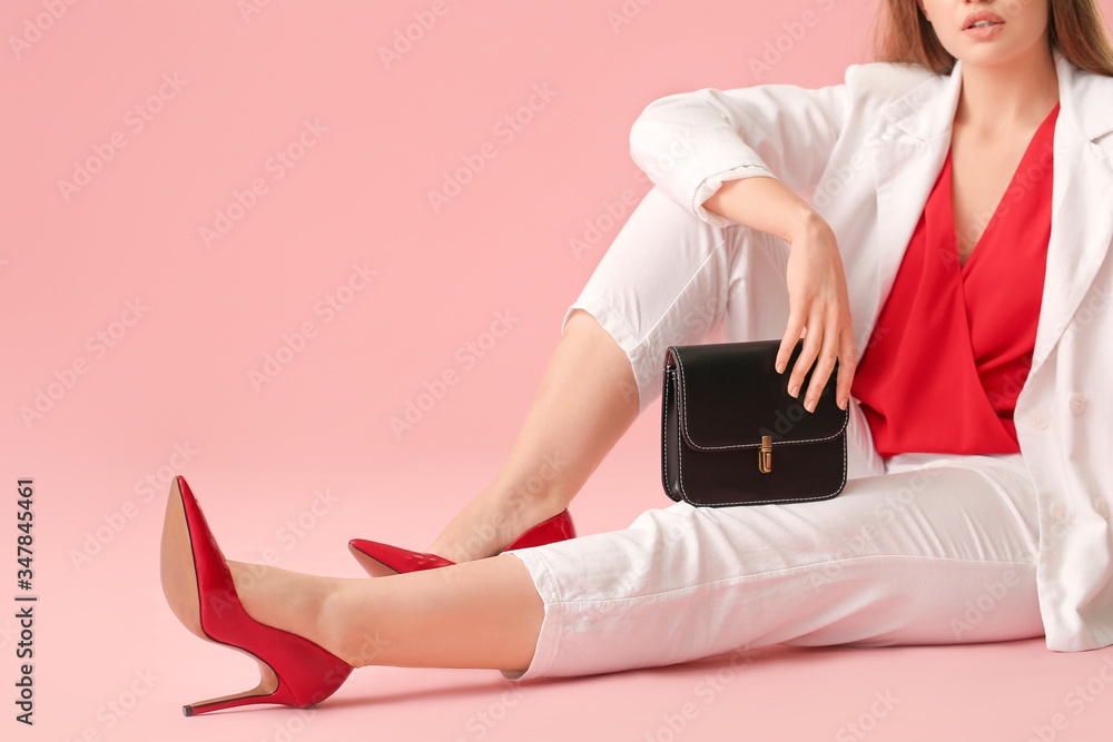 Beautiful woman with stylish bag on color background