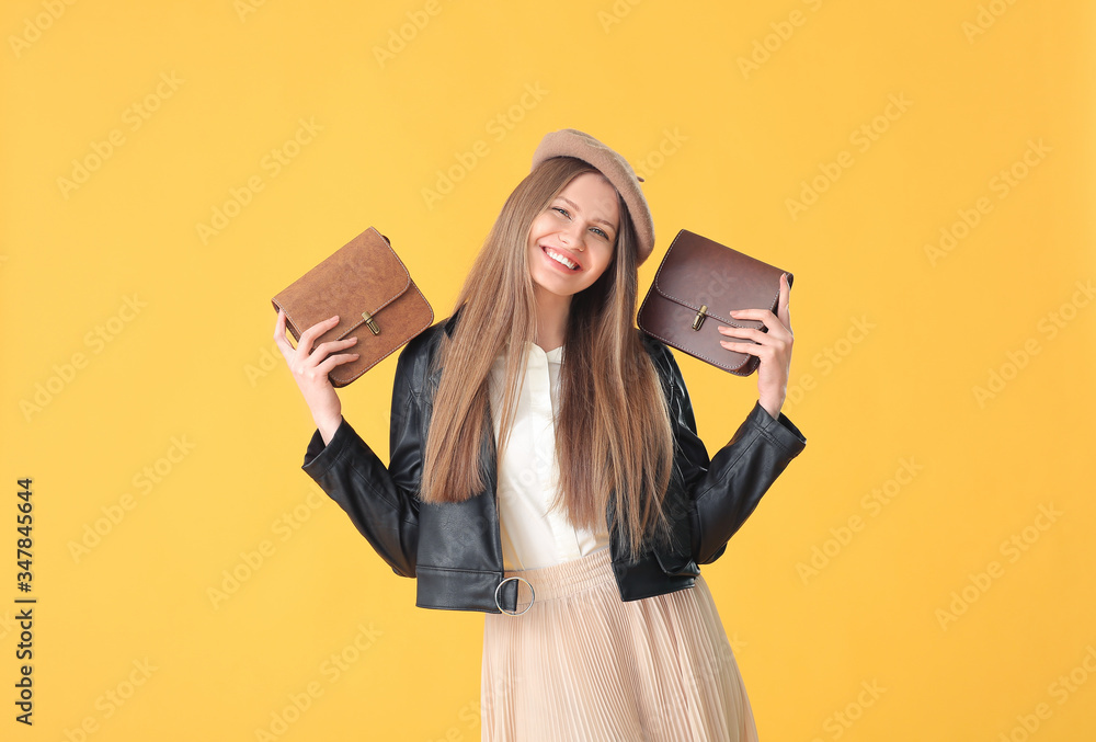 Beautiful woman with stylish bags on color background