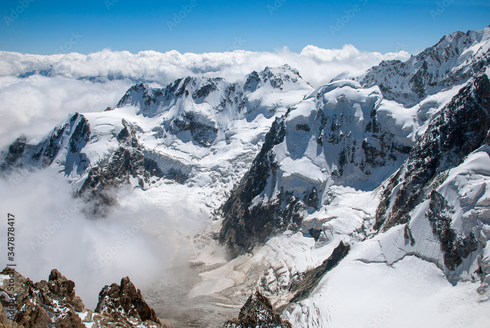 高山景观，岩石山峰被雪和云覆盖