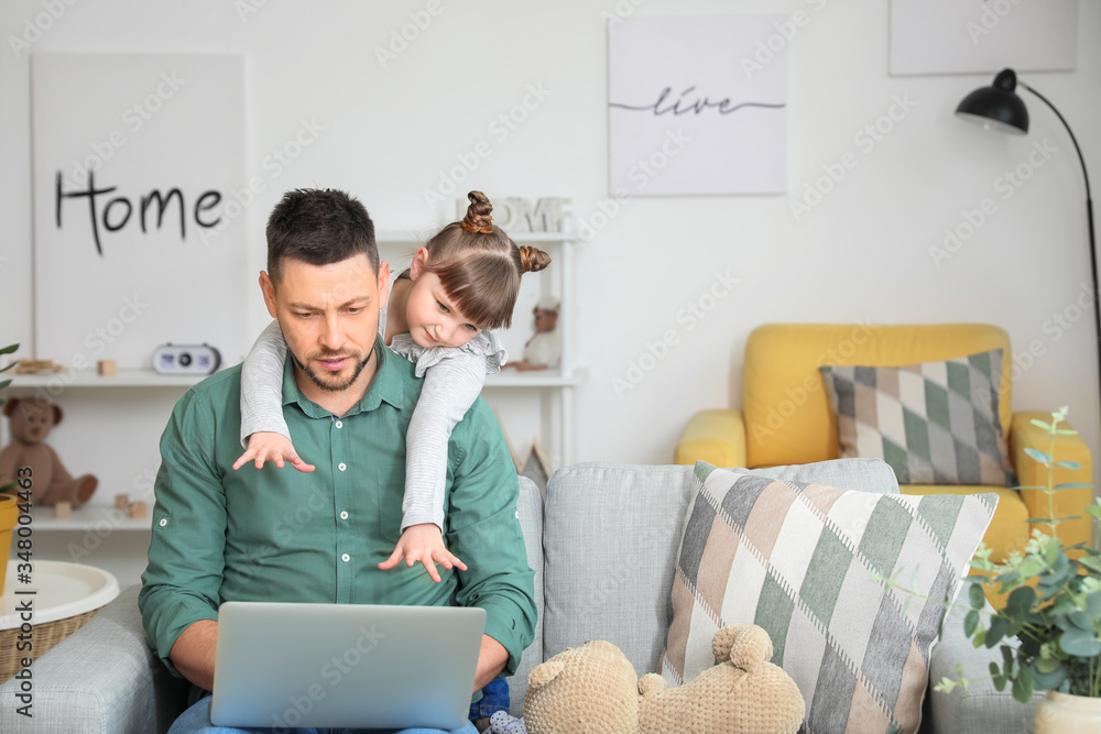 Working father with naughty little daughter at home